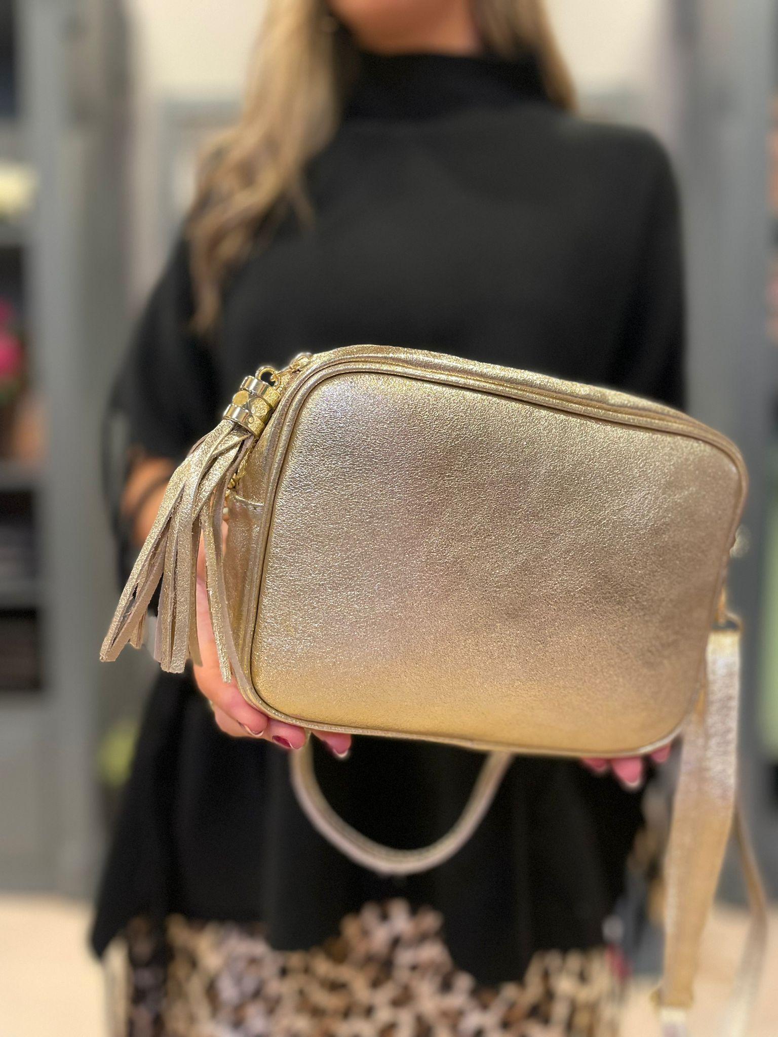 Bolso de piel dorado con un compartimento y asa larga regulable