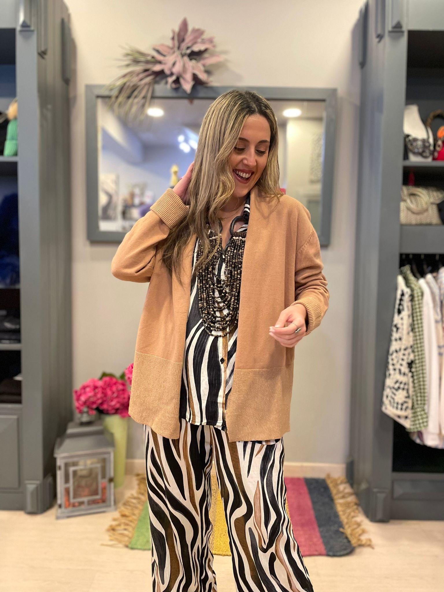 Chaqueta camel con detalles en brillo dorado en los puños y la parte inferior.