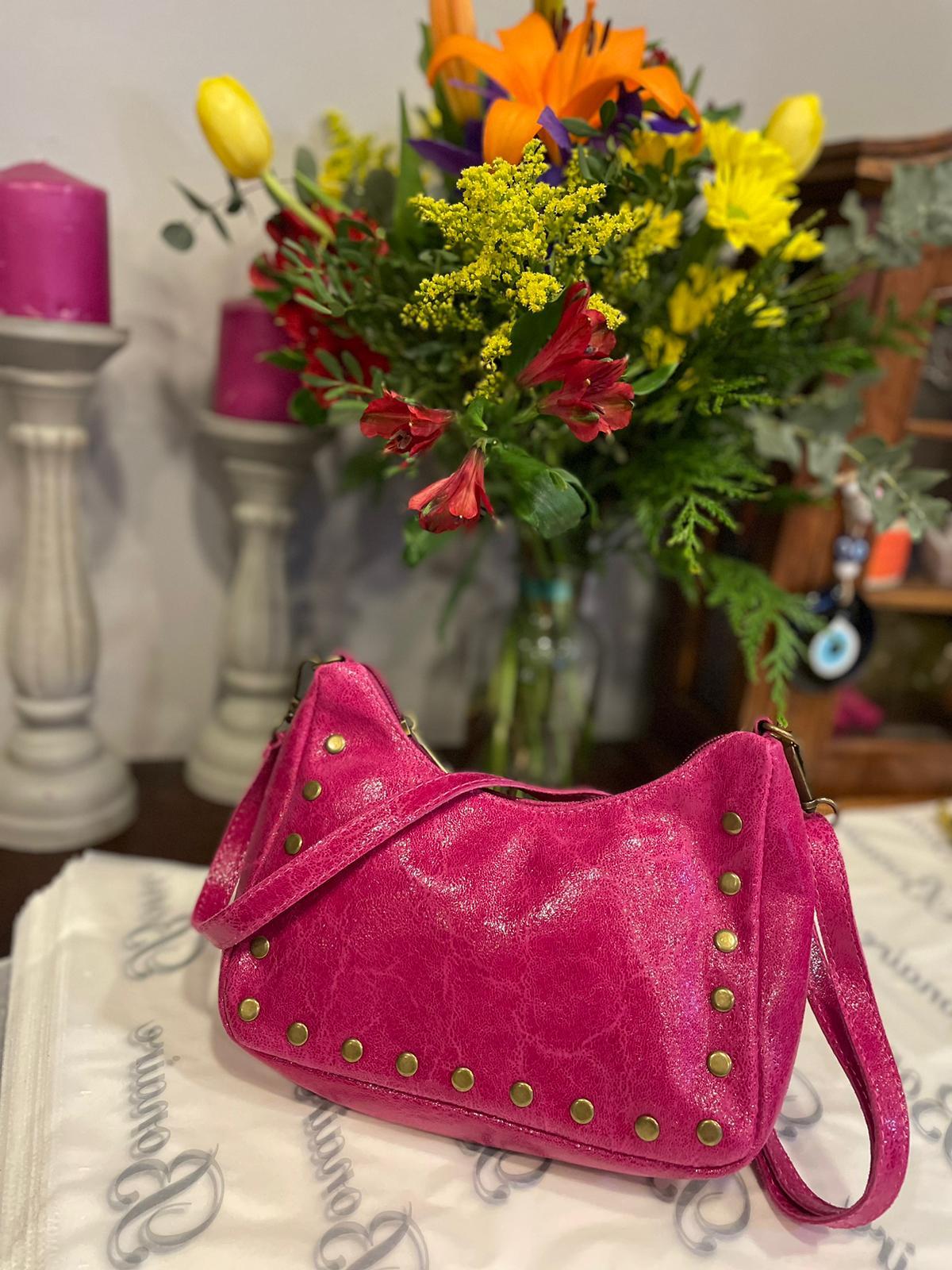 Bolso de piel con tachuelas y asa largo regulable.